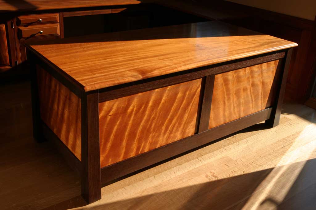 When we came across a pair of curly mahagony boards 20" wide, we knew we had something special.The wood was enough  to wrap entirely around this CEO's desk. It appears to light up from inside out.