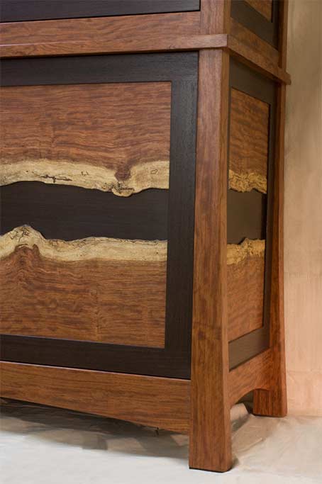 The bubinga legs flair slightly to visually give strength to this gun case. The natural figure of the panels directed the design.
